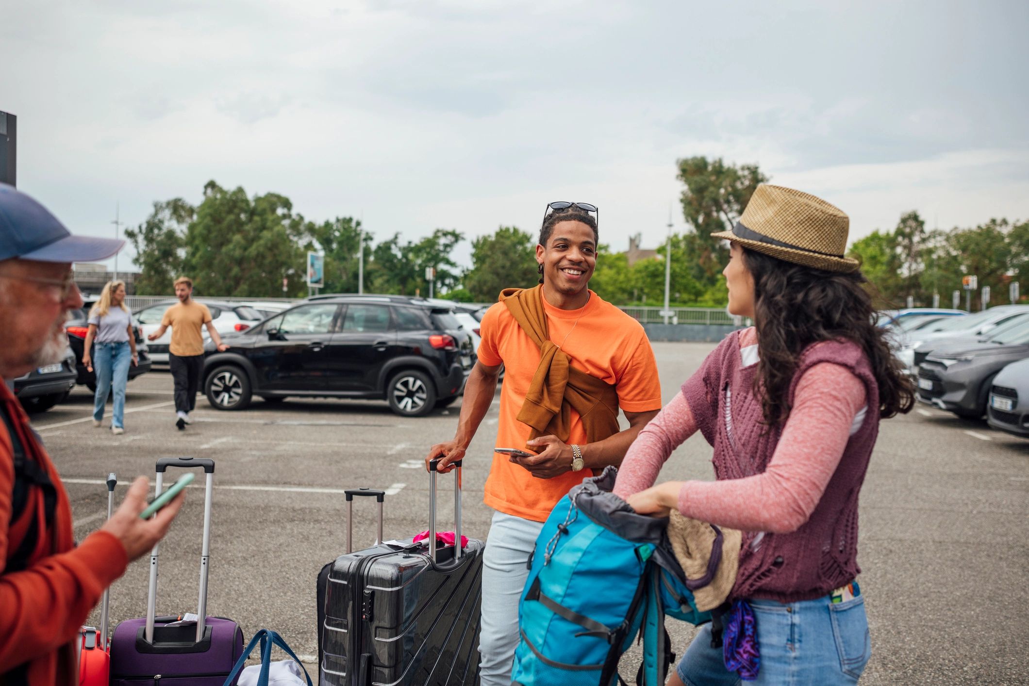 Travel group waiting together at an airport car park